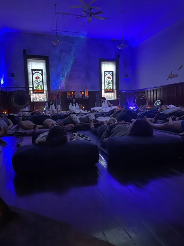 Participants resting during an atmospheric sound healing session bathed in blue light