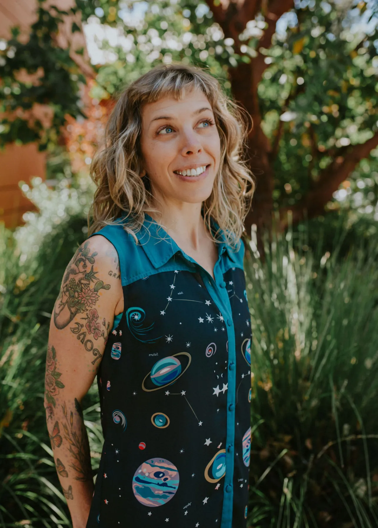 LeeAnna smiling outdoors in a celestial-print dress