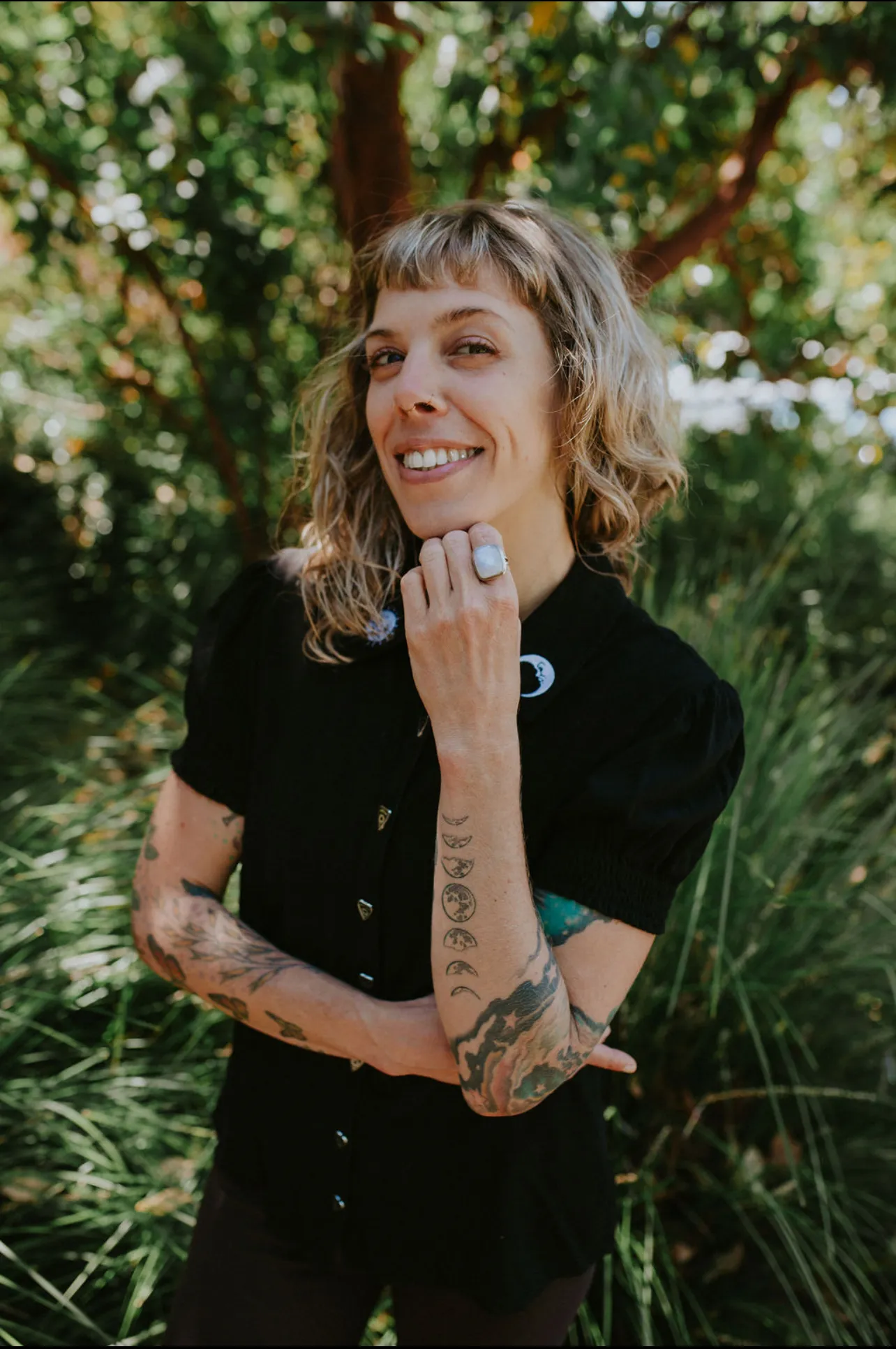 LeeAnna outdoors wearing moon phase pins, smiling