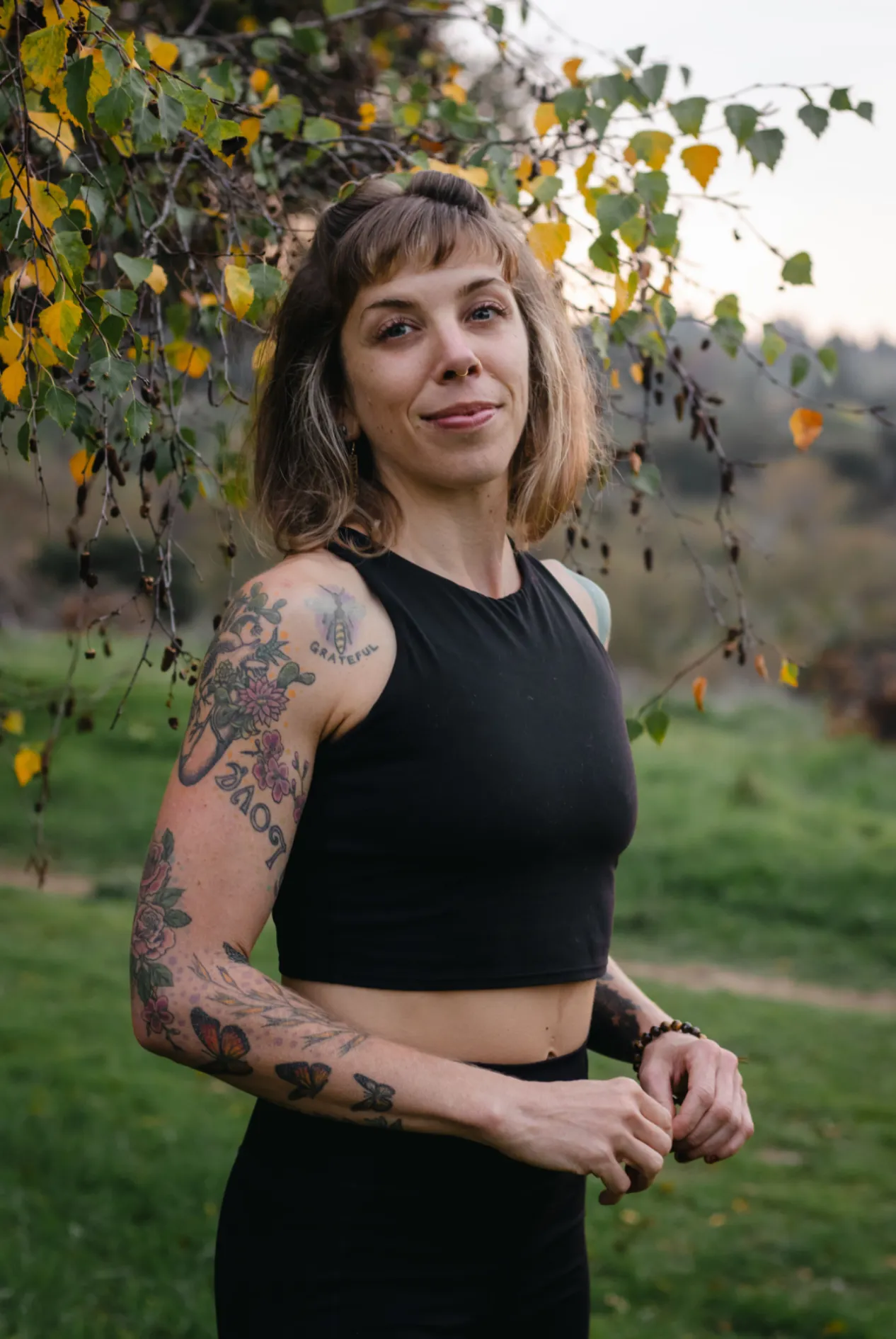 LeeAnna Gregorio standing outdoors among autumn leaves