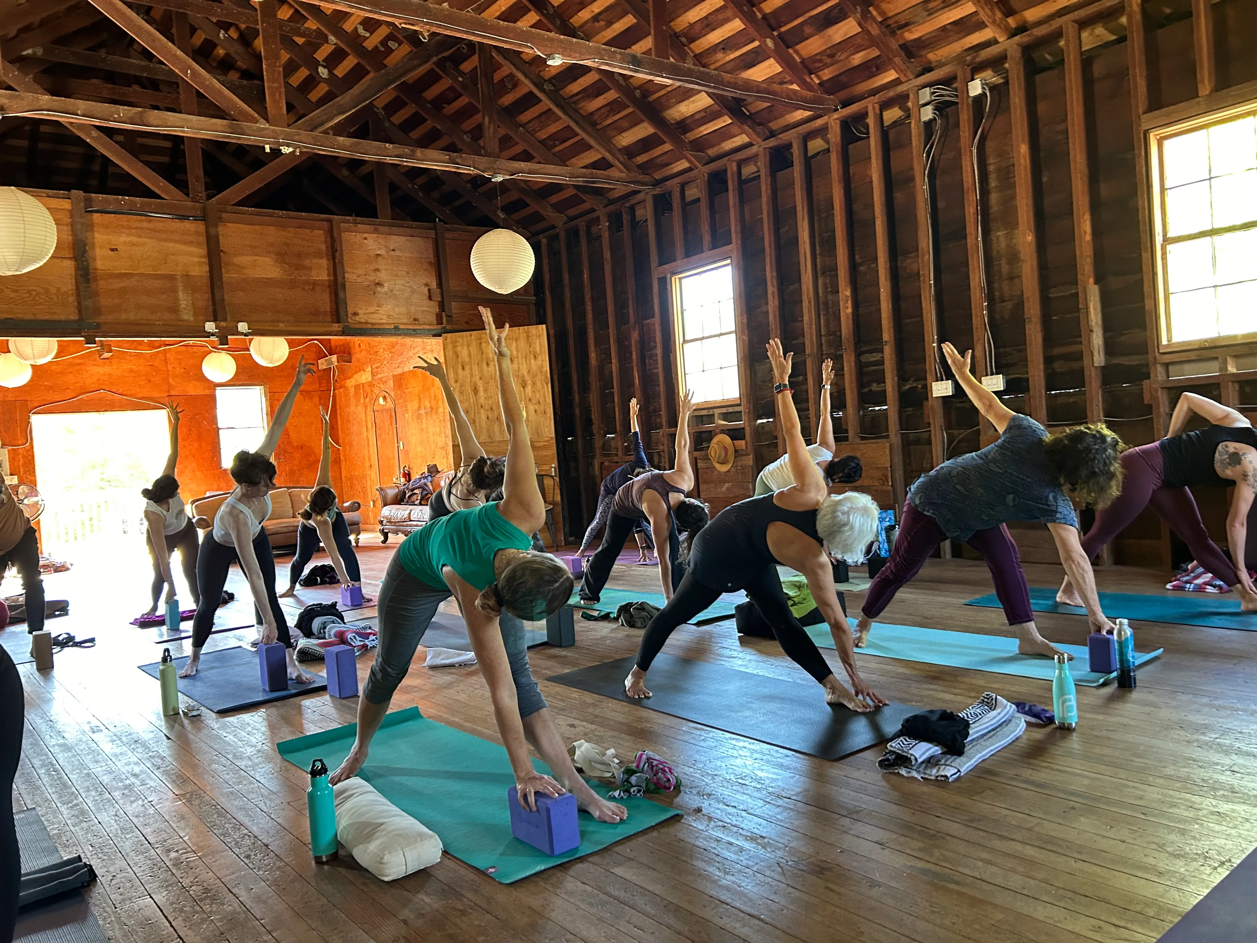 LeeAnna leading a group yoga class in a rustic wooden studio